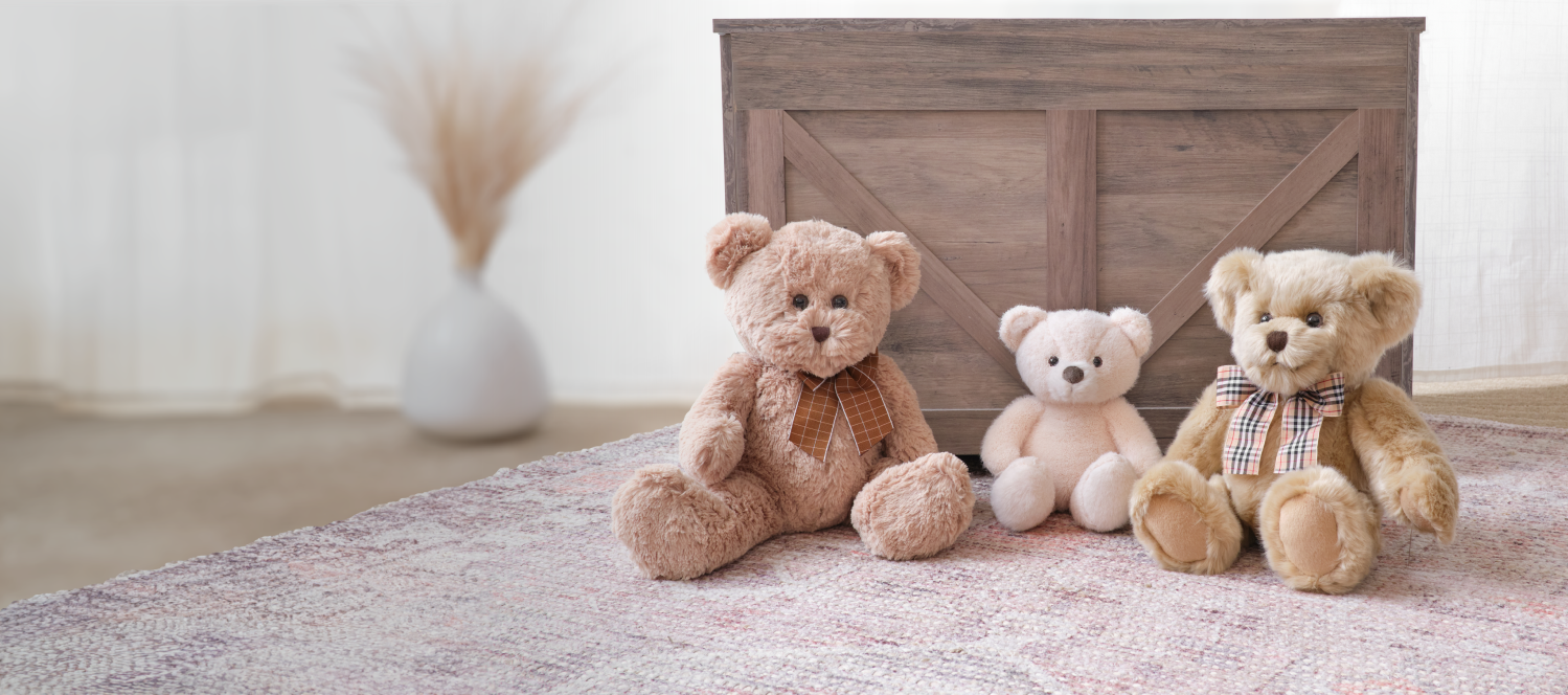 Three Bearington Bears sitting in front of a wooden cabinet